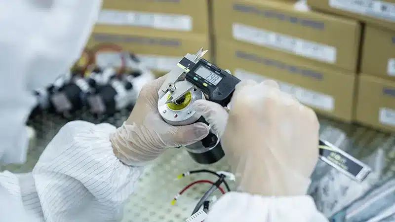 Ebara parts supplier – precision semiconductor spare components Technician inspecting and measuring Ebara parts with a digital caliper in cleanroom