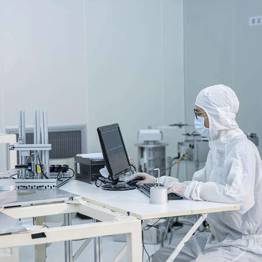 Cleanroom technician operating computer and equipment related to KLA semiconductor systems